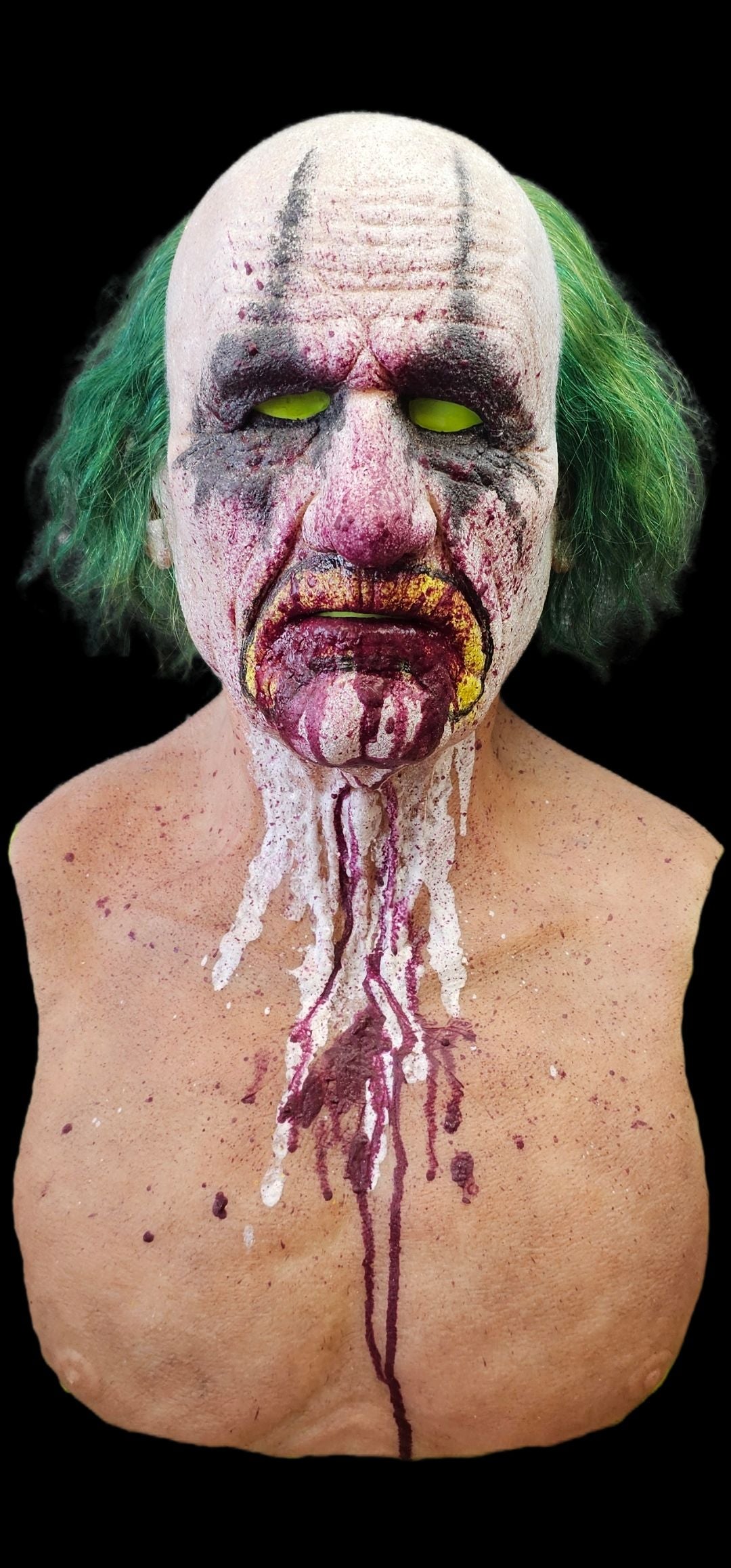 Silicone mask with green hair and clown makeup, appearing distressed