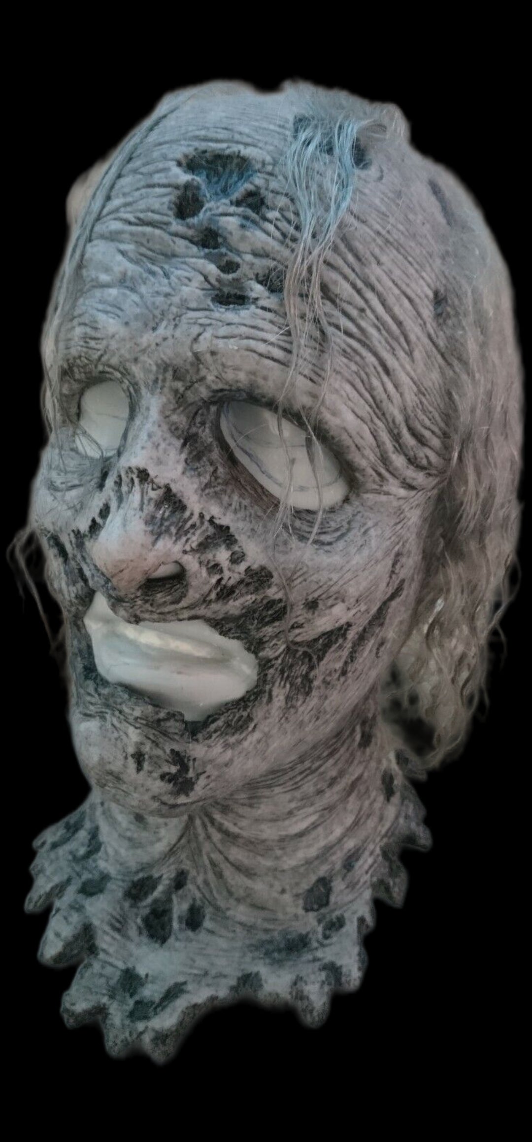 Detailed walking dead silicone mask with textured surface on a black background